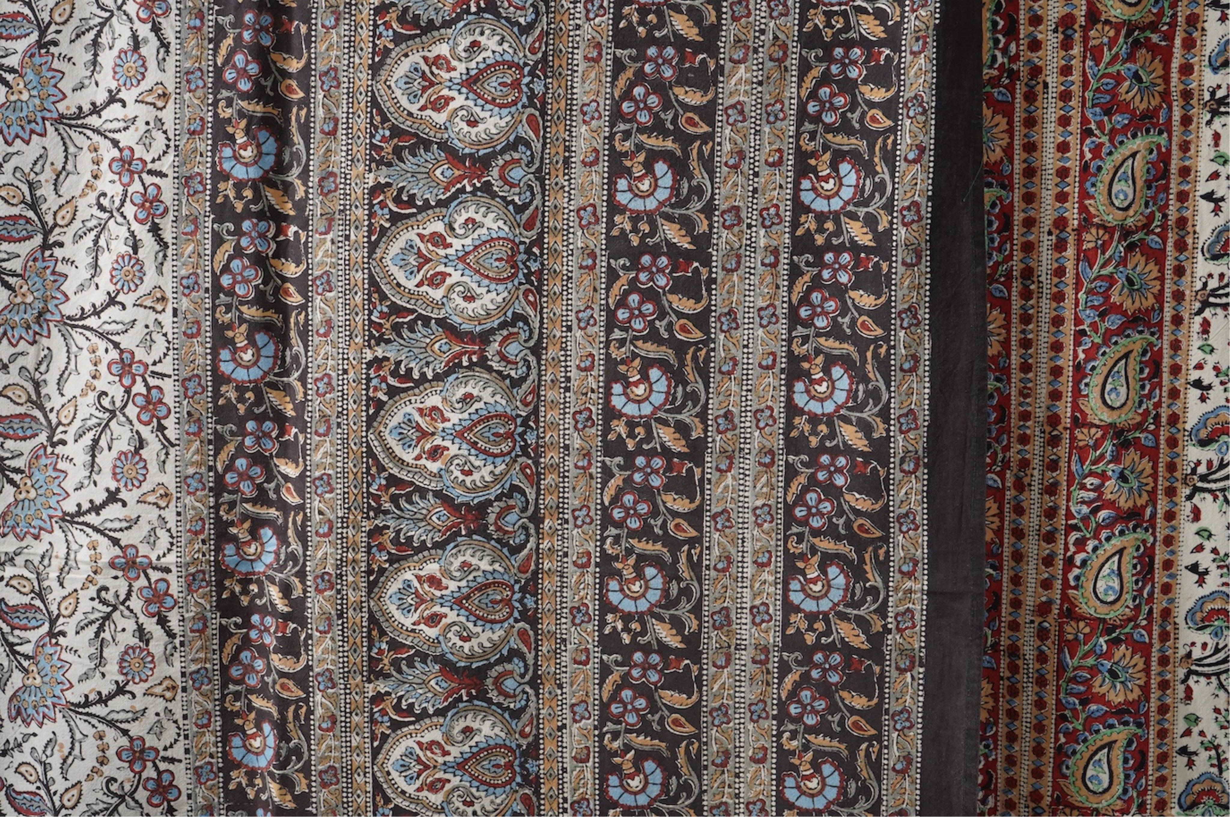 Two late 20th century large Indian block printed cotton bedcovers. One printed with brown borders, the other with brick red borders, both with large central panels designed in a classical Indian floral vining design. Bro